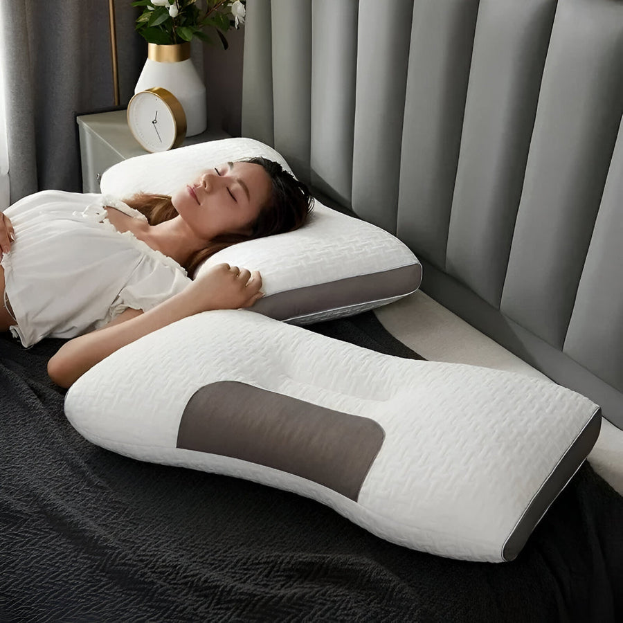 Woman sleeping on her side on the pillow in a bright bedroom with a nightstand and plant.
