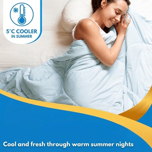 Woman lies on a pillow smiling, wrapped in a light blue blanket in bed.
